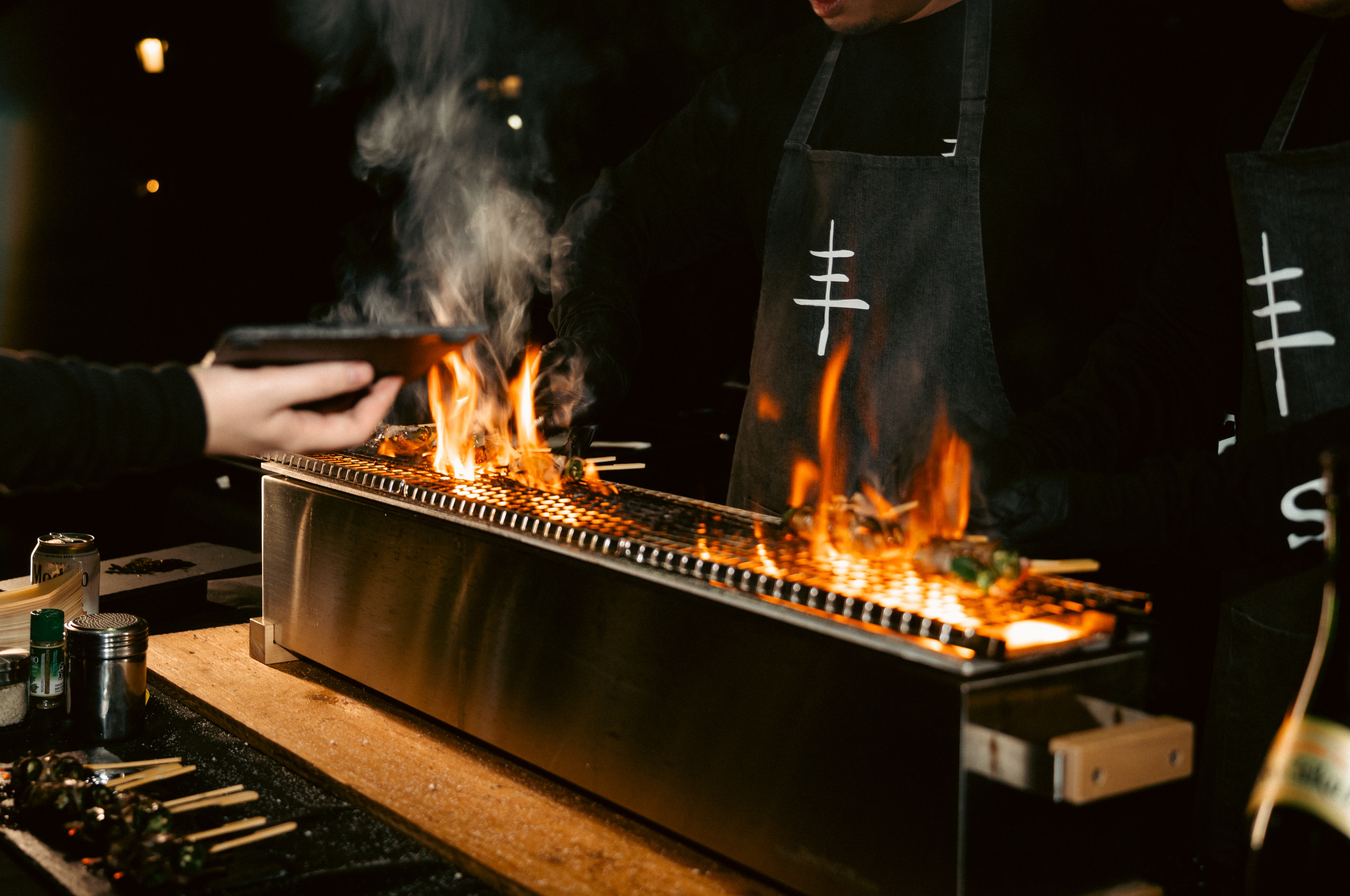 Yakitori grilling over open flame at a San Ban Yakitori event